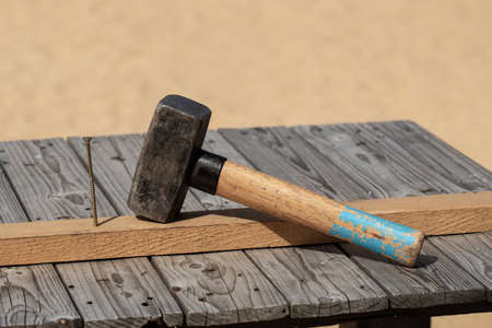 Hammer and nail on the old wood worktableの写真素材