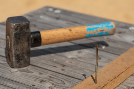 Hammer and nail on the old wood worktableの写真素材