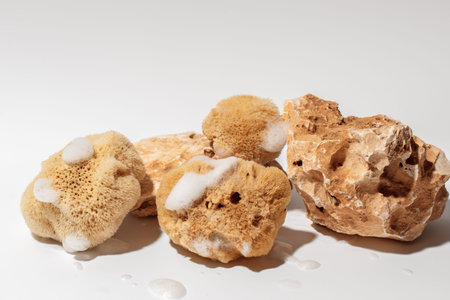 Yellow Natural bath or cleaning three sea sponges with foam and stones on white background