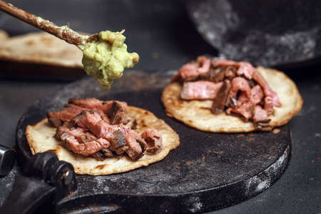 Process of cooking tacos with grilled flank beef steak with handmade guacamoleの写真素材