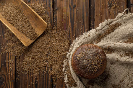 Round loaf of rye bread with thyme on rustic style wooden table top viewの写真素材