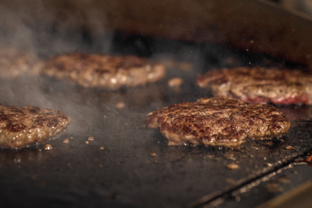 Process of cooking cheeseburgers on the grill.  Close up beef meat burgers for hamburgerの写真素材
