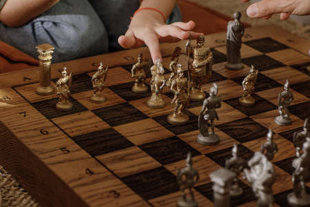 Ancient metal Roman Chess Set with silver and gold plated pieces on solid oak wood Board. Concept image for business strategy, competition, relaxation, recreation and mental agility.の写真素材