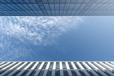 City skyscrapers bottom view against blue sky. Low wide angle shot, from ground. Glass facade...