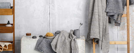 Organic waffle linen towels in grey shades, bamboo toothbrushes, bathroom zero waste accessories in contemporary bathroom interior. Daily body care, spa and wellness zero waste bathroom conceptの写真素材