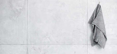 Organic waffle linen towel hanging on nail in grey shades contemporary bathroom interior. Daily body care, spa and wellness zero waste bathroom conceptの写真素材