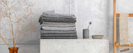 Organic waffle linen towels, bamboo toothbrushes, bathroom zero waste accessories in grey shades in contemporary bathroom interior. Daily body care, spa and wellness zero waste bathroom conceptの写真素材