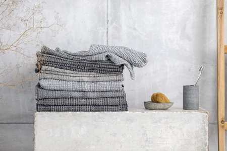 Organic waffle linen towels, bamboo toothbrushes, bathroom zero waste accessories in grey shades in contemporary bathroom interior. Daily body care, spa and wellness zero waste bathroom conceptの写真素材