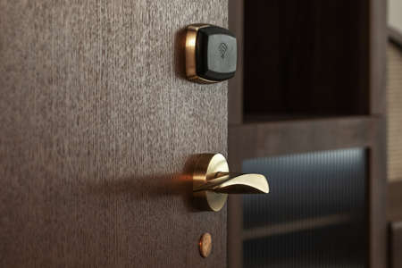 Modern electronic card lock in the hotel wood door for secure access. Hotel security system conceptの写真素材