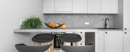 Kitchen counter with oranges in metal basket in clean modern kitchen interior