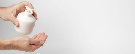 Man disinfecting hands with sanitiser. Personal hygiene routines helping to prevent COVID-19...