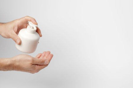 Man disinfecting hands with sanitiser. Personal hygiene routines helping to prevent COVID-19...