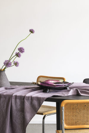 Elegant table setting with craft ceramic tableware, eggplants in plate, decorative garlic in vase....