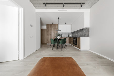 Modern minimalistic kitchen and dining room interior with wooden and white surfaces, green chairs...