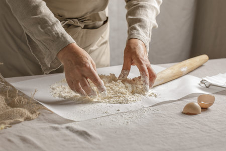 Womenâ€™s hands, flour and dough. A woman is preparing a dough for home baking. Concept of home...