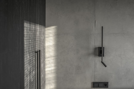 Minimalistic black wall light in modern interior in grey and black colours, concrete wall design, clay wall. Contemporary interior design aesthetics with concrete detailsの写真素材