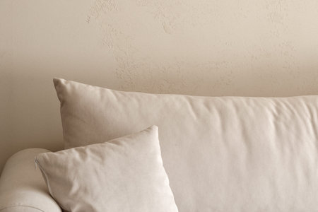 sofa detail with pillow against clay wall in earthy tones. Wabi-sabi interior conceptの写真素材