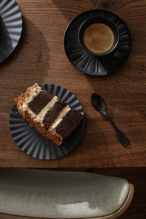 Dark chocolate handmade cake served on black plate on oak tableの写真素材