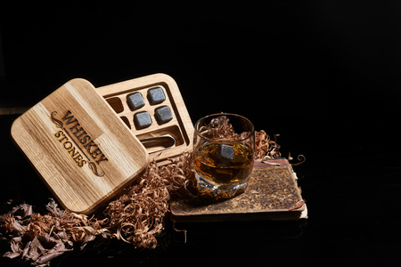 Irish whiskey. Glass of whisky with wiskey stones. Elegant glass of whiskey with Whiskey stones. Scotch Whisky in the glass. Irish Whiskey with oak boxの写真素材