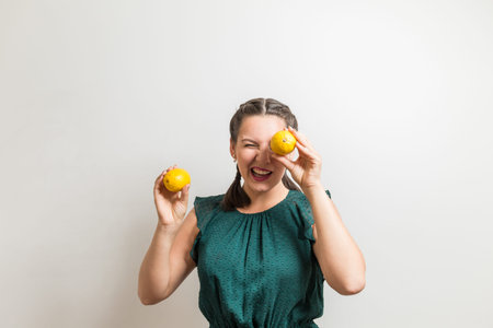 Cute girl winks and holds lemon fruits