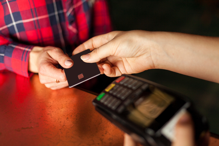 Woman insert card in terminal to pay for coffeeの写真素材
