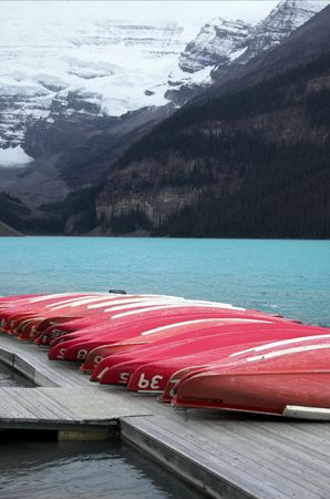 Canoes on dock at Lake Louise with glacier on mountains behind.の写真素材