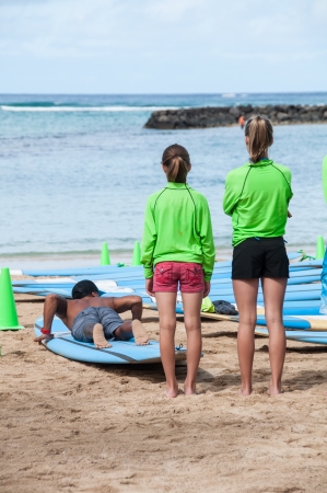 Tourists learning to surf on Waikiki beach June 27, 2013 in Oahu. Waikiki beach is beachfront neighborhood of Honolulu, best known for white sand and surfing.のeditorial素材
