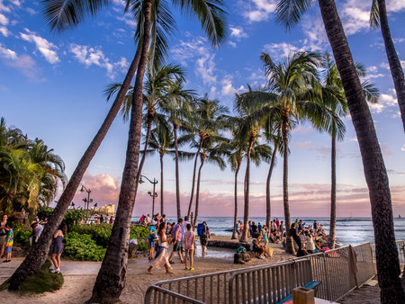 Tourists on the beach front at sunset on Waikiki beach April 27, 2014 in Oahu  Waikiki beach is beachfront neighborhood of Honolulu, best known for white sand and surfing  のeditorial素材