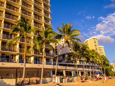 Tourists on the beach front at sunset on Waikiki beach April 27, 2014 in Oahu. Waikiki beach is beachfront neighborhood of Honolulu, best known for white sand and surfing.のeditorial素材