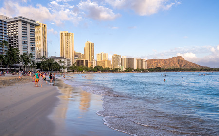 Tourists on the beach front at sunset on Waikiki beach April 27, 2014 in Oahu. Waikiki beach is beachfront neighborhood of Honolulu, best known for white sand and surfing.のeditorial素材