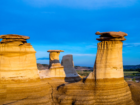 Hoodoos bathed in the warm light of a summer sunset at Drumheller Alberta Canada.の写真素材