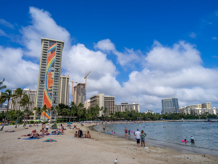 HONOLULU, USA - AUG 7: Sun lovers on Waikiki beach at the Hawaiian Hilton on August 7, 2016 in Honolulu, Usa. Waikiki beach is neighborhood of Honolulu, best known for white sand and surfing.のeditorial素材