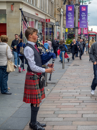 GLASGOW, SCOTLAND - JULY 21: A bagpiper on Buchanan Street on July 21, 2017 in Glasgow, Scotland. Buchanan Street is a popular tourist destination and so there is always a bagpiper busking for change.のeditorial素材