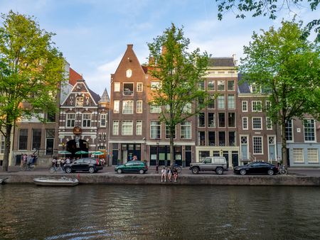 Buildings and boats along Amsterdam's beautiful  canals in central Amsterdam during the day. The canals are one of Amsterdam's main attractions.のeditorial素材