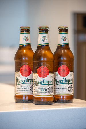 Calgary, Alberta - June 22, 2021: Pilsner Urquell lager beer bottle in white kitchen. Pilsner...