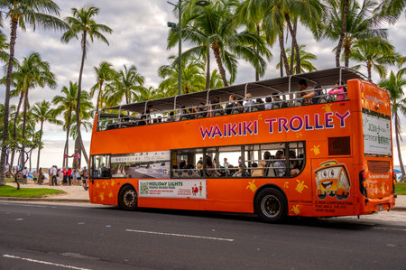 Honolulu, Hawaii - December 29, 2022: The Waikiki Trolley picking up tourists on Kalakaua Avenue.