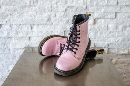 Calgary, Alberta - January 29, 2023: Pink patent leather Dr. Martens kids boots.