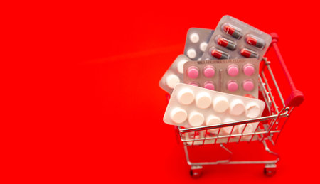 Shopping basket with medicines with space for your text on a red  background