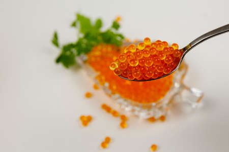 Caviar in a spoon and in a bowl isolated on a white background. Luxury culinary food background.の写真素材