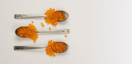 Caviar in a spoon isolated on a white background. Luxury culinary food background.