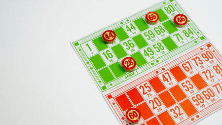 Board game of lotto or bingo. Wooden barrels with game cards on a white isolated background. The concept of sitting at home.の写真素材