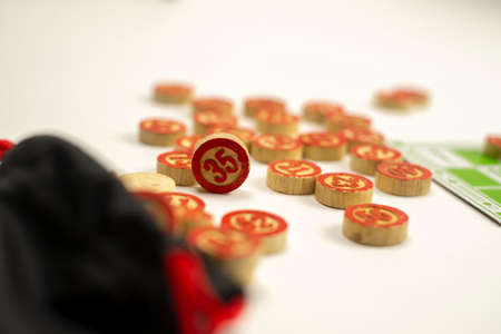 Board game of lotto or bingo. Wooden barrels with game cards on a white isolated background. The concept of sitting at home.の写真素材
