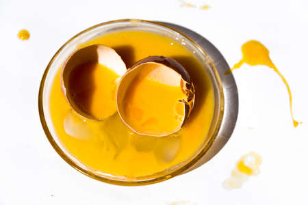 a broken egg, egg white and yolk, black background, copy space, food conceptの写真素材