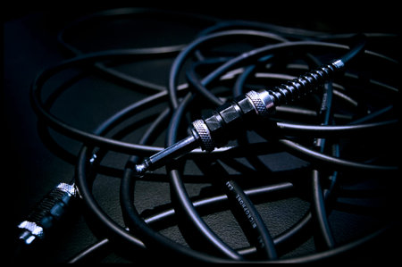 A bundle of audio cables on an amplifier, black and white