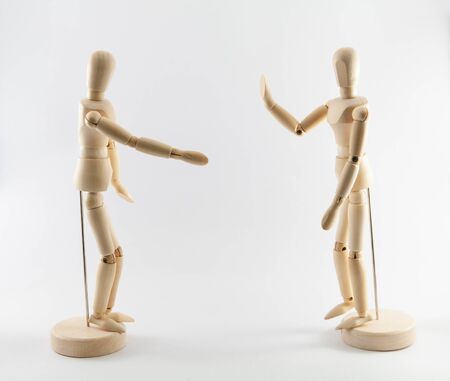 Wooden puppets on white background with social distancing concept. Gesture of one puppet refusing to shake hand. Concept of coronavirus infection prevention.の写真素材