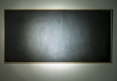 A dusty blank chalkboard with very dramatic lighting.の写真素材