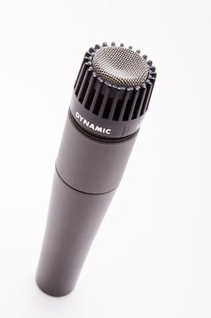 A dynmaic microphone stands at an angle on whiteの写真素材