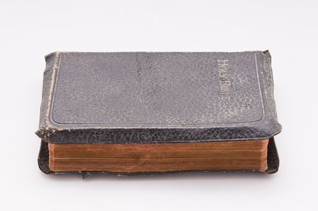 Very old leather bound bible sits sideways on whiteの写真素材