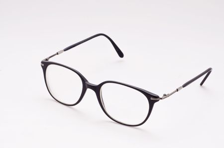 Nerdy black framed glasses sit open on whiteの写真素材