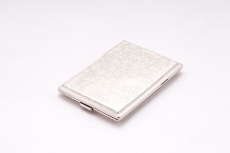 A silver cigarette case sits on white with room for copyの写真素材